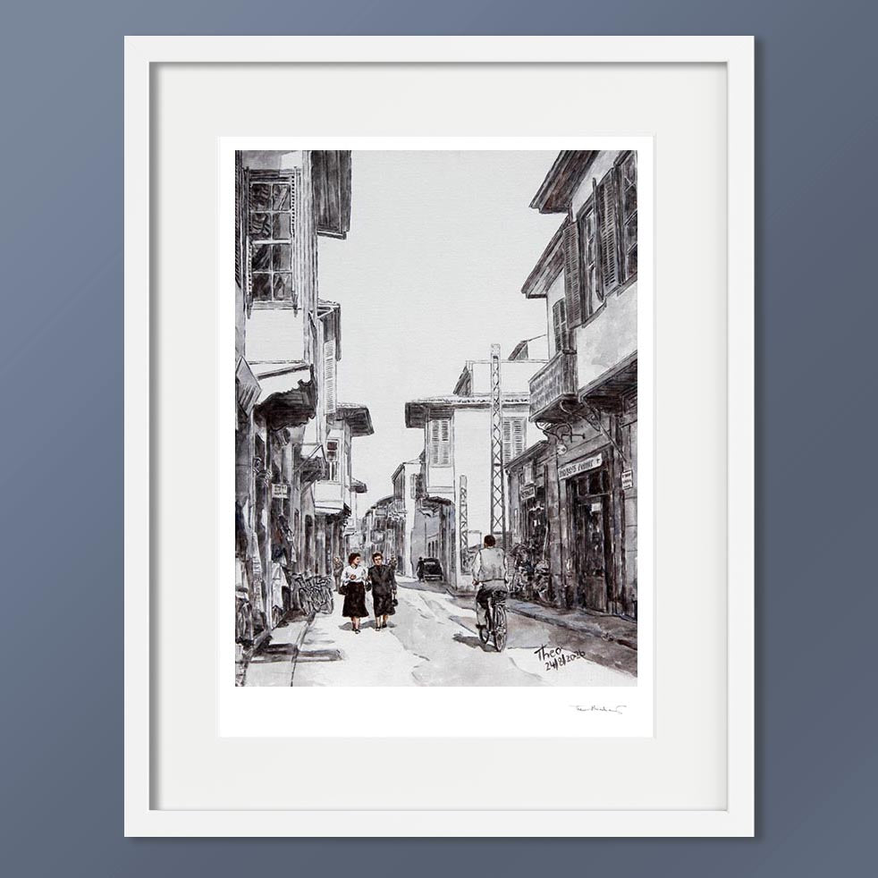 A black and white hand signed fine art print, depicting Ledra street around the 1950s, featuring traditional buildings, pedestrians and a cyclist.