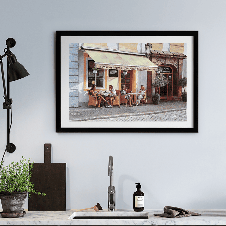 Fine Art Print print of an Italian restaurant painting by Theo Michael. perfect painting for the kitchen were diners enjoy a leisurely meal under the shade of a canopy. The cobblestone street and surrounding potted plants add to the charming European ambiance.